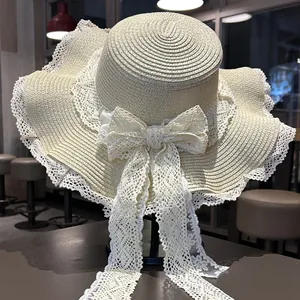 Elegante cappello di paglia a tesa larga con fiocco in pizzo per il sole in spiaggia