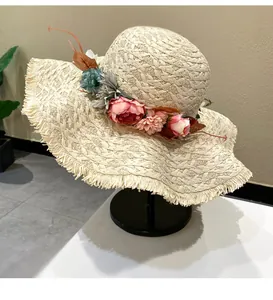Detailed side view of a beige raffia sun hat with colorful floral wreath and large brim
