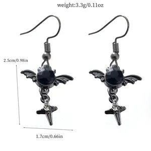 Gothic style bat wing earrings with a black gemstone and a silver cross pendant