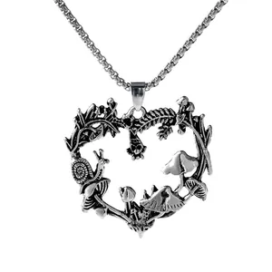 Detailed macro view of the intricate heart-shaped pendant with mushrooms and vines.
