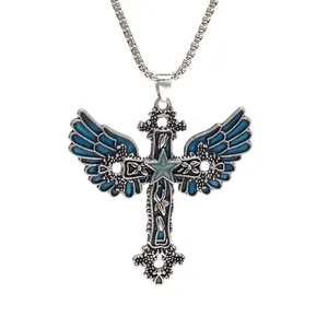 Close-up of vintage gothic cross necklace with blue enamel wings and star pendant