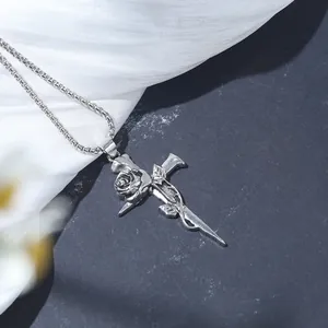 Close-up of a vintage silver rose thorn cross pendant on a dark and silk background.