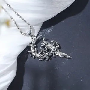 Close-up detail of vintage silver witch on crescent moon necklace with thorny vines.