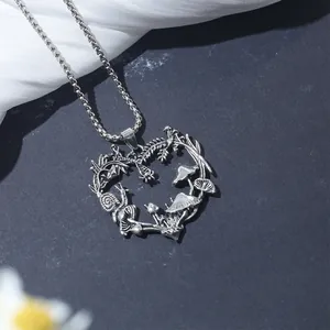 Detailed view of a vintage silver heart necklace with mushroom and vine carvings.