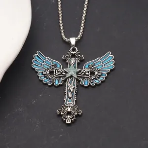 Close-up of gothic cross pendant with blue angel wings and luminous star on a box chain.