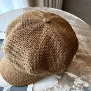 Close-up detail of a brown textured newsboy cap showing its high-quality knit fabric pattern