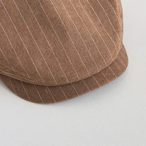 Détail du tissu à rayures tennis marron et des coutures soignées d'une casquette plate vintage