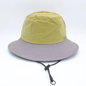 Detail of a two-tone bucket hat with an adjustable chin strap and ripstop fabric