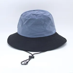Detailed view of a two-tone bucket hat in blue and black with adjustable chin strap.