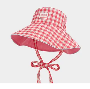 Detalle de un sombrero de pescador de cuadros rosas y blancos con lazo ajustable