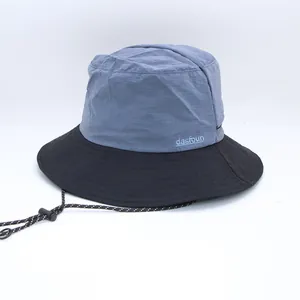 Detail view of stylish two-tone blue and black bucket hat with adjustable chin strap