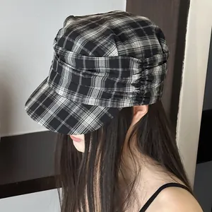 Detailed macro view of a vintage black and white plaid newsboy hat with pleated side detailing