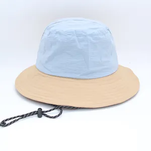 Detail showing color-block bucket hat with adjustable drawstring and grid texture