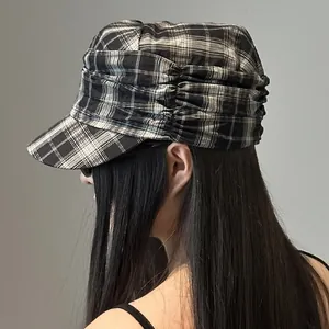 Vintage black and white plaid newsboy cap with pleated detail on a side model view