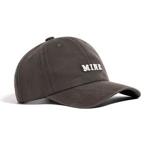 Detail view of a vintage washed grey baseball cap with 3D white MINE embroidery text.