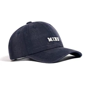 Close-up detail of navy blue washed cotton baseball cap with white MINE embroidery