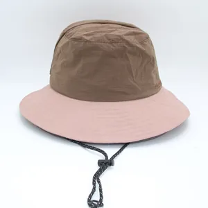 Detailed view of a two-tone bucket hat in brown and pink with adjustable drawstring