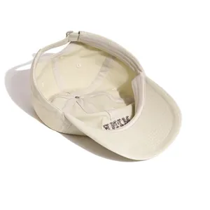 Interior detail of a cream washed cotton baseball cap with embroidered lettering.