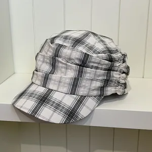 Detailed view of a retro British style plaid newsboy cap with unique pleated fabric design