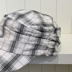 Close-up view showing pleated detail and plaid pattern of this vintage newsboy cap.