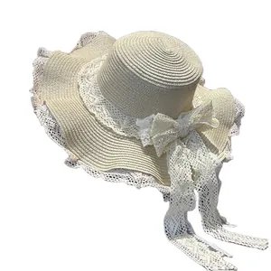 Elegante cappello di paglia a testa piatta da donna con fiocco in pizzo bianco per la spiaggia