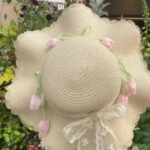 Elegant garden style straw sun hat featuring pink tulips decoration and a white lace bow