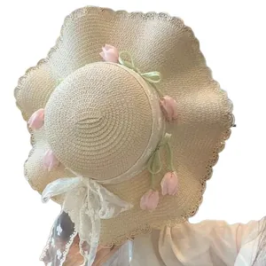Elegant wide brim straw sun hat with pink tulips and lace bow for beach summer trips