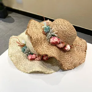 Handmade raffia straw hat with floral garland and frayed wide brim for beach vacation