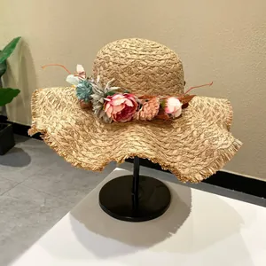 Hand-woven raffia straw hat with an elegant flower garland and wide brim for summer