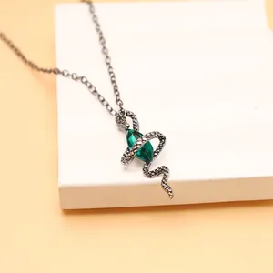 Nahaufnahme einer dunklen Vintage Schlangen-Halskette mit grünem Marquise-Edelstein
