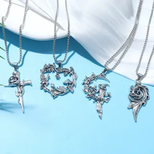 Detail view of silver witch, mushroom, and moon pendant necklaces on blue background