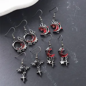 Detailed view of multiple gothic style red moon earrings with bat and butterfly motifs