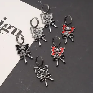Detailed close-up of gothic butterfly ribbon hoop earrings in black, red and white enamel finish
