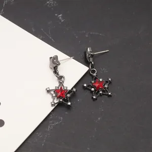 Detailed view of black gothic star drop earrings with a vibrant red crystal center