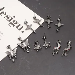 Macro view of dark gothic butterfly and crescent moon pendant earrings set on display