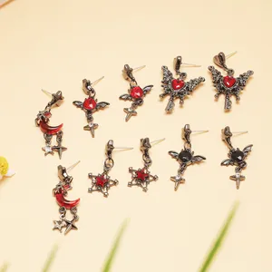 Collection of gothic dark style earrings with red gems and celestial motifs in black finish.