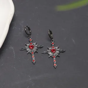 Detailed view of Gothic black cross earrings featuring a red heart gem and small red crystals