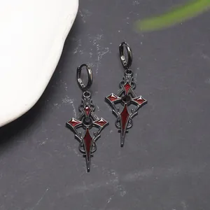 Close-up of gothic blood moon cross earrings with red enamel and black metal finish