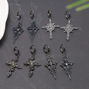 Macro detail of various gothic cross hoop earrings in dark metallic finish