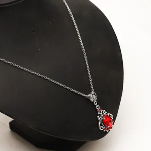 Vue détaillée d'un collier rubis de style victorien vintage sur un présentoir de bijoux noir.