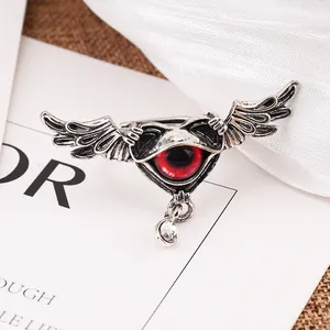 Close-up of punk winged heart ring with a striking red eye and clear crystal drop.