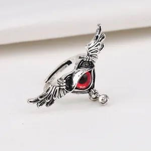 Detailed close-up of punk winged heart ring with a striking red evil eye design.