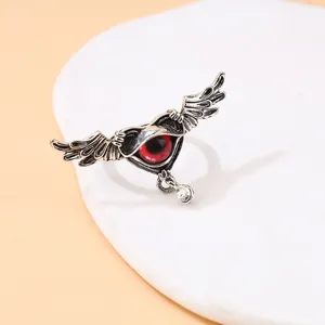 Detailed macro view of a gothic punk ring featuring a winged demon eye with a stone