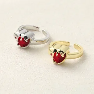 Close-up of gold and silver plated melting heart rings with red crystals