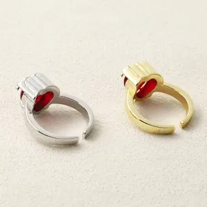 Close-up detail of two crown heart red zircon open rings in gold and silver finish