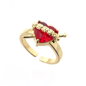 Gold plated copper open ring featuring a red crystal heart pierced by a tiny sword