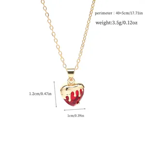 Close-up detail of red heart crystal necklace with gold dripping metal design pendant