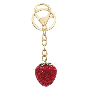 Close-up of a sparkling strawberry keychain with full red rhinestones and gold clasp.