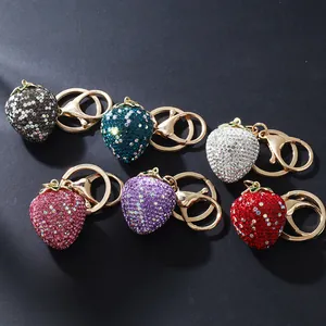 Detailed view of six sparkling rhinestone strawberry keychains in various colors