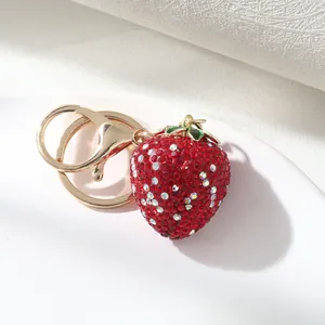 Detailed close-up of a luxury red rhinestone strawberry keychain with shiny gold ring